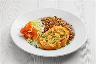 Plate with chopped meat backed with tomato with buckwheat and cabbage salad