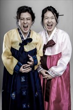 Two woman in Korean traditional costume with open mouth