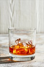 Whiskey with ice on bright background