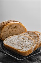 Closeup view of artisan whole grain wheat bread cut on slices on wooden table