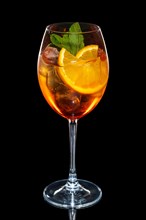 Cherry and orange cocktail with ice cubes in wine glass isolated on black