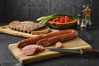 Smoked lamb sausage rings on wooden cutting board on kitchen table