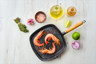 Top view of unpeeled shrimp with head in cast iron skillet