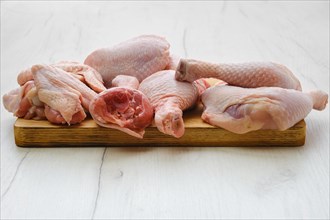 Variety of fresh chicken meat on wooden cutting board