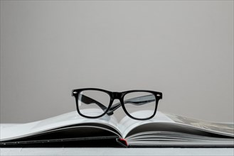 Front view open book with glasses