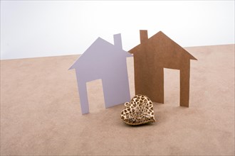 Heart shaped icon and paper houses on a brown background