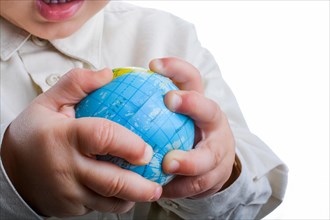 Baby holding a small globe in hand on white background