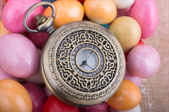Mechanical pocket watch on colorful candy sweets