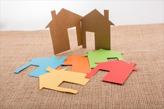 Little house shape cut out of colorful paper on a canvas background