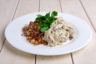 Beef stroganoff with creamy onion sauce and buckwheat with fried mushrooms