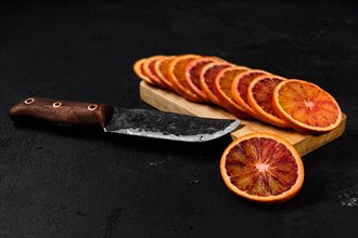 Overhead view of slices of blood orange on black background