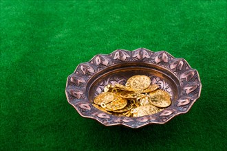 Fake gold coins in an old decorative metal plate