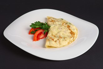 Angle side view of omelet with ham and vegetables