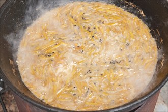 The making of pilaf in cauldron