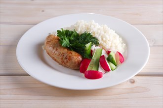 Fried sausage with rice and fresh cucumber and radish