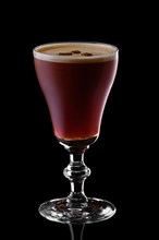 Glass of espresso martini isolated on black background