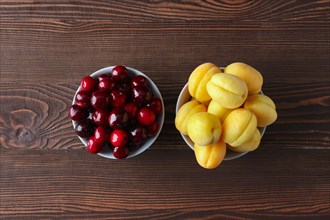 Cherries and apricots on dark wooden background