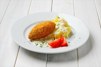 Cutlet stuffed with cheese with mashed potato on white wooden table