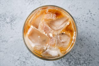 Top view of iced coffee with fat cream in rocks glass