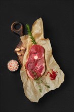Raw fresh lamb center cut leg steak with spice on wrapping paper