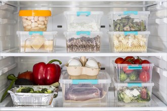 Open fridge with plastic food containers vegetables. Resolution and high quality beautiful photo