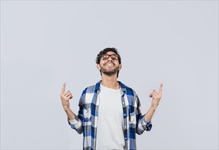 Smiling man in glasses pointing fingers up