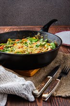 Beef and vegetables stir fry in pan on wooden table