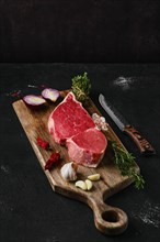 Raw top sirloin beef steak on wooden cutting board