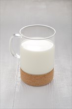 Glass of milk on white wooden kitchen table