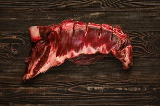 Overhead view of raw deer ribs over wooden background