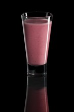 Glass of raspberry and strawberry cocktail isolated on black