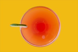 Top view of cosmopolitan cocktail on yellow background