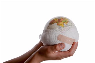 Child holding a globe with plaster in his hand on a white background