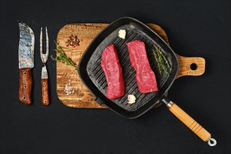 Top view of raw boneless beef loin steak on cast iron skillet