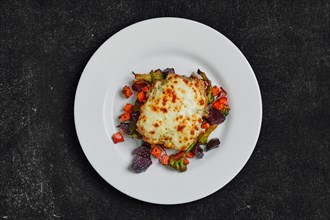 Top view of cod fillet baked with cheese topping served with fried beet