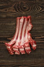 Overhead view of raw fresh doe ribs over dark wooden background