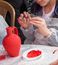 Young children decorating their handmade clay pottery