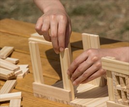 Hand holding wooden puzzle element in hand