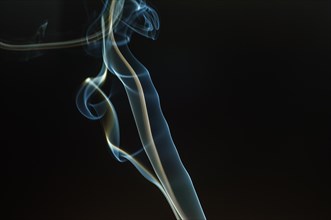 Trajectory of incense smoke in the air showing different shapes. France