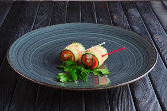 Appetizer for reception. Piece of salmon rolled in long slice of cucumber topped with sesame