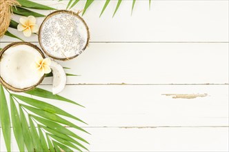 Green palm leaves with coconuts wooden table