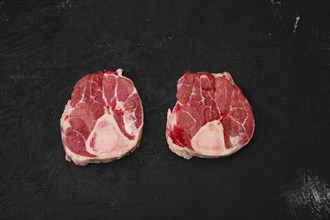 Raw beef ossobuco steak on black background