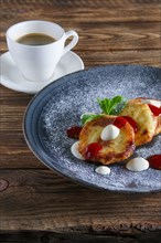 Cheese pancakes served with sour cream and strawberry jam