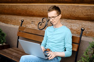 Middle aged man choosing a gift online using laptop outdoors