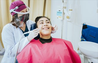 Female dentist cleaning a patient mouth with a drill. Close-up of a stomatologist cleaning a woman teeth