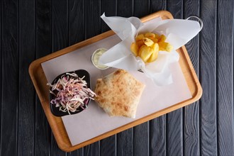 Beef cutlet with cheese rolled in pita with fried potato and red cabbage