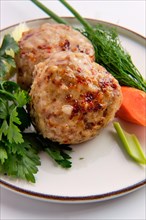 Close up view of meatballs served with fresh carrot