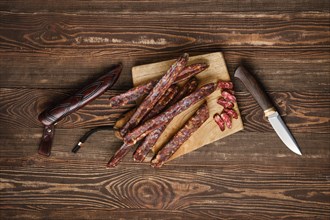 Air dried homemade beaver sausages on wooden background