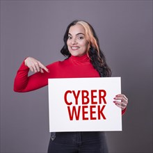 Beautiful woman pointing at a Cyber Week sign. Commercial concept. Commerce
