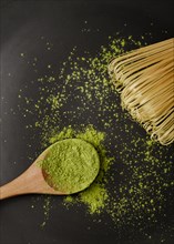 Close up matcha tea powder wooden spoon with bamboo whisk